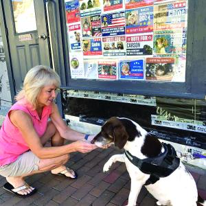 Philo, candidate for king of Wiscasset, offers a paw Aug. 30 to Laurie Winslow, a friend of his owner Cynthia Pappas. Signs in town declared local pets’ candidacies for offices real and not real. SUSAN JOHNS/Wiscasset Newspaper  