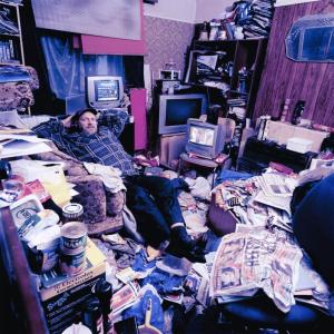 man relaxing in hoarder house