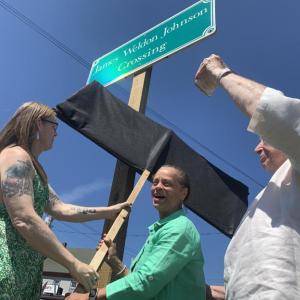 From left, Heather Jones and State Sen. Rachel Talbot Ross unveil one of the new signs naming the Main Street, Wiscasset railroad crossing James Weldon Johnson Crossing, as Terry Heller holds a phone on which Johnson’s great niece Melanie Edwards and Tony Hill, past lawmaker in Johnson’s native Florida, attend via Zoom June 26. SUSAN JOHNS/Wiscasset Newspaper Ceremony