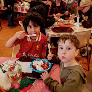 From left, Alissa Eason and Christopher Hart’s grandsons Damián Incháurregui, left, and Asher Williams, 4, share a treat at St. Philip’s Episcopal Church’s 71st Strawberry Festival in Wiscasset June 28. Bob Bond/40 Federal Studio photo Festival