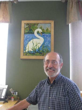 Artist Jim Taliana in front of his painting “Swan” at First Federal Savings.
